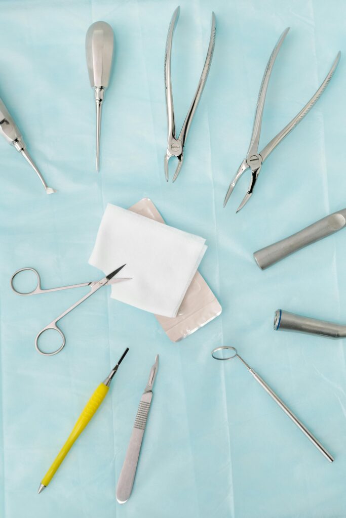 Top view of assorted dental surgical instruments on a blue background, sterile and ready for use.